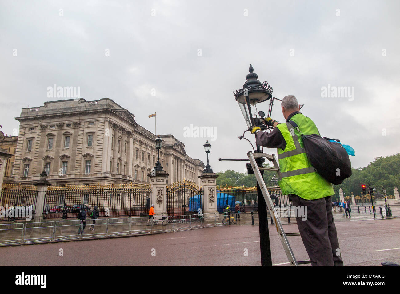 London street light gas lighters turning off the street lights outside Buckingham Palace Stock Photo