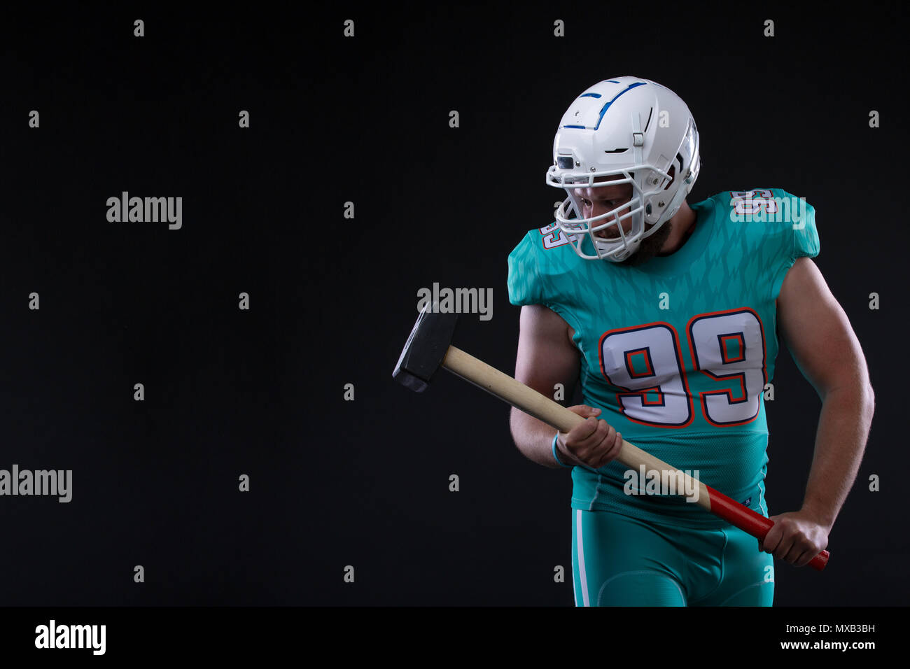Aggressive American football player in blue jersey screaming against black  background. rugby player holding a hammer. Copy space Stock Photo - Alamy