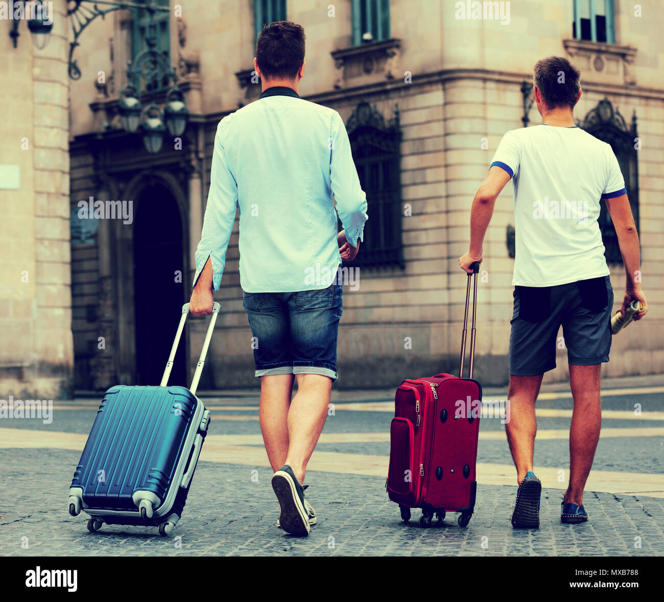 Rear view of two guys with luggage at city street Stock Photo Alamy
