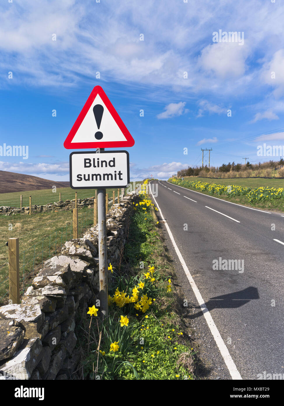 dh Blind summit ROAD ORKNEY Red Triangle warning sign empty road scotland signs Stock Photo