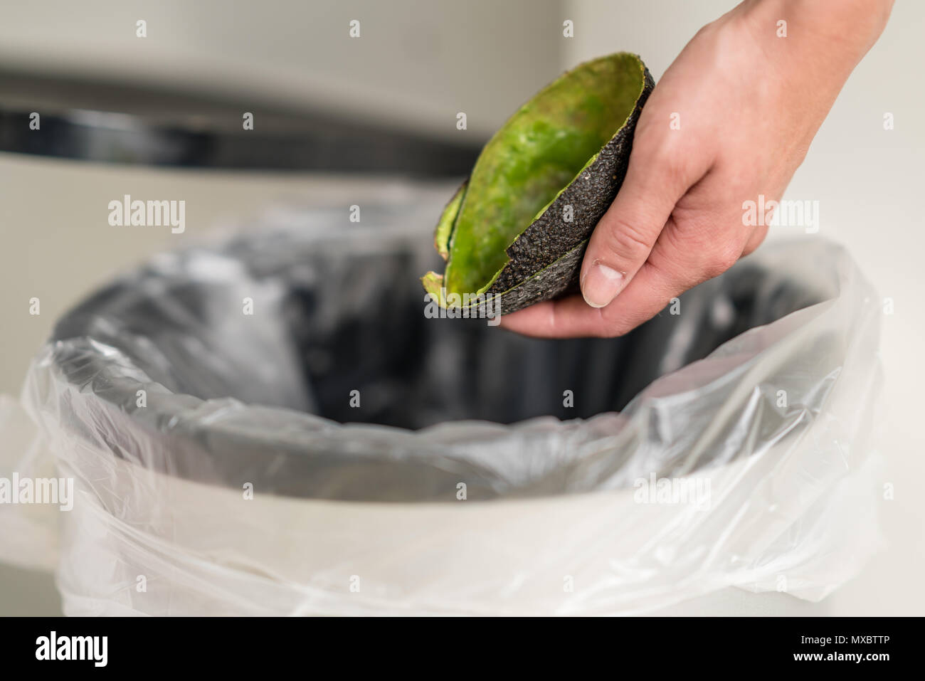 Woman dumping organic trash into the garbage can. Stock Photo