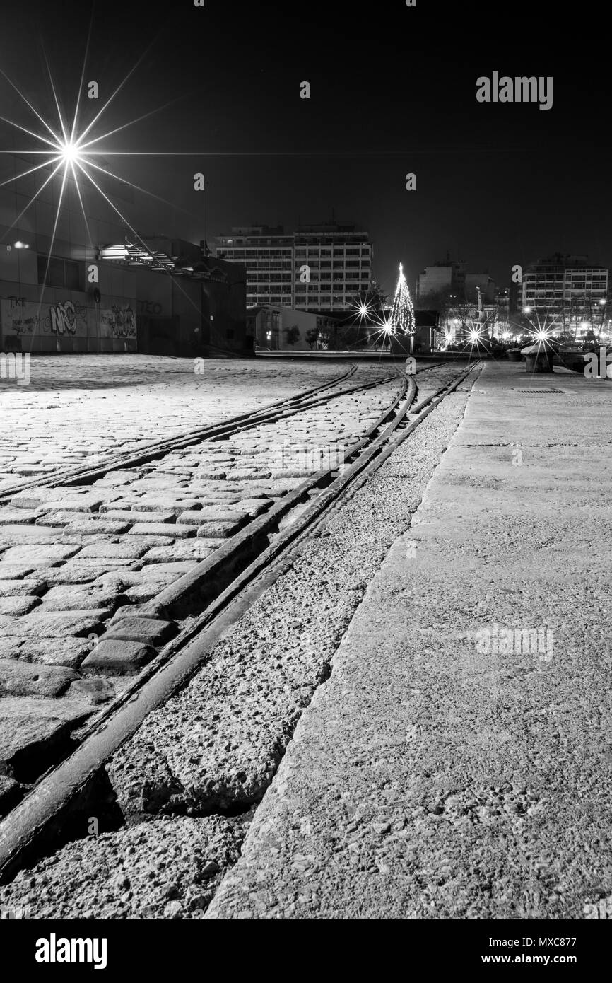 Thessaloniki, Greece, long exposure night photo of the harbor with crane rails in front. Black and white image. Stock Photo