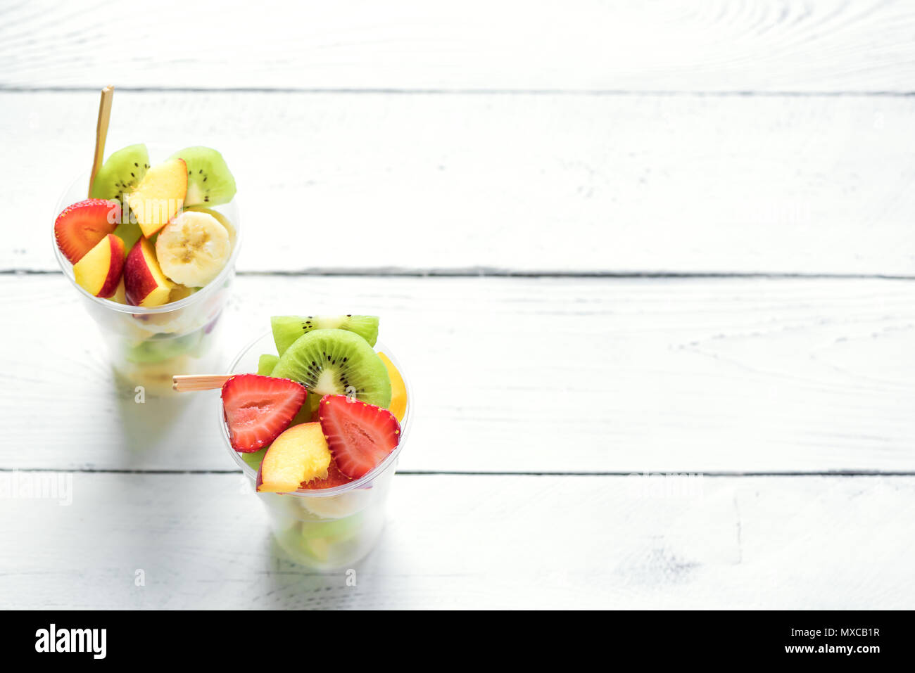 Fruit salad in plastic cups takeaway. Sliced organic fruits and berries