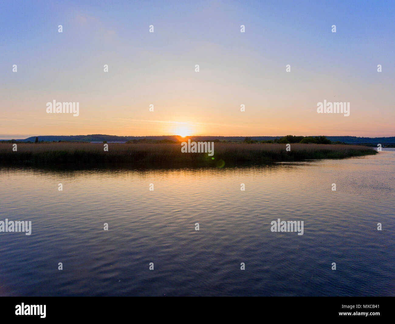 Sunset reflected over the River Medway and reed beds, Kent, UK Stock Photo
