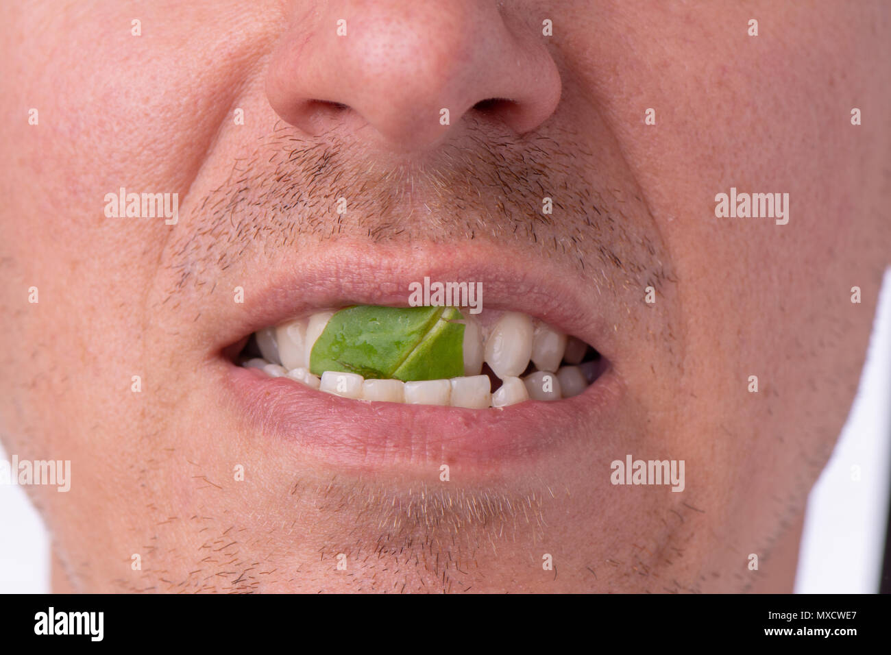 Close-up of bearded man smiling with spinach or salad stuck in her teeth Stock Photo