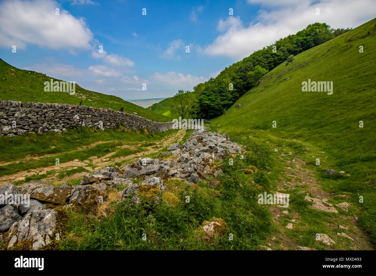 Pathway beside stone wall leading into Cavedale in the English Peak District Stock Photo