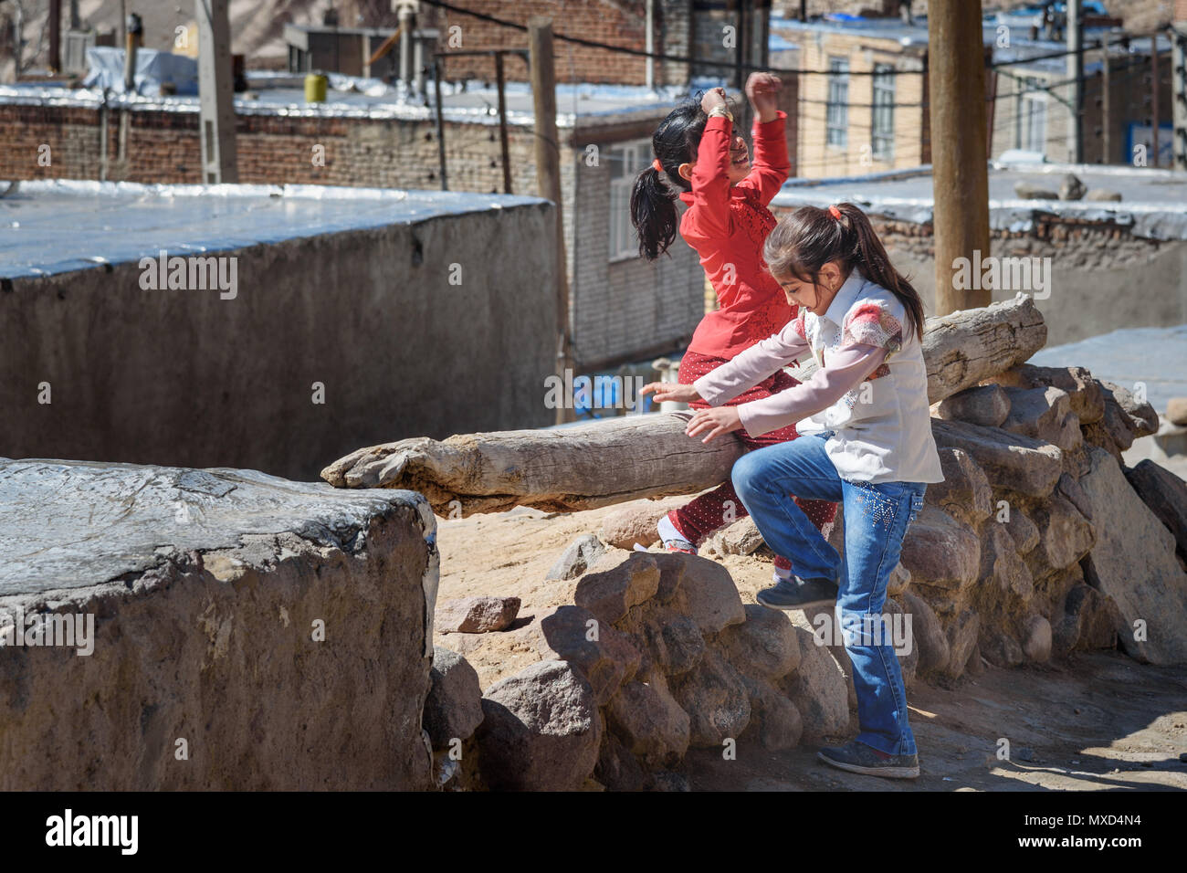 Kandovan, East Azerbaijan province, Iran - March 16, 2018: Two Iranian girls playing on the street in rock village Kandovan Stock Photo