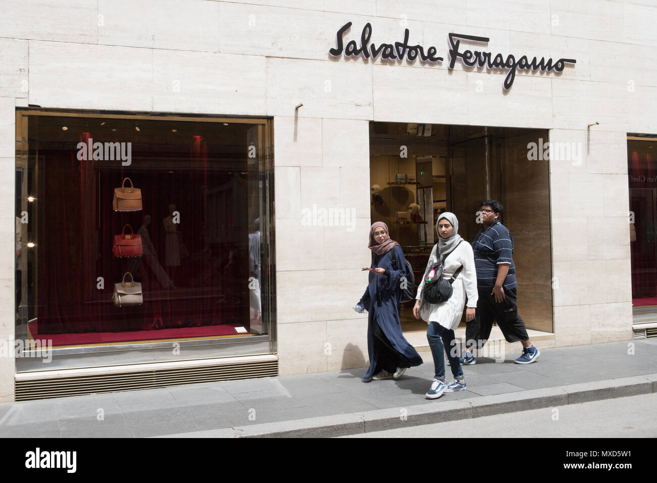 Via Condotti Rome, three Arabs people walking in front of  'Salvatore Ferragamo' store. Made in italy fashion stylist. Stock Photo