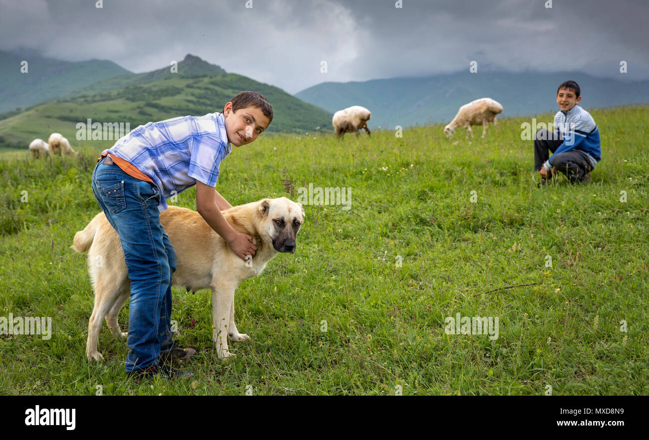 Tatev, Armenia, 1st June, 2018: armenian boy with his dog in a countryside Stock Photo