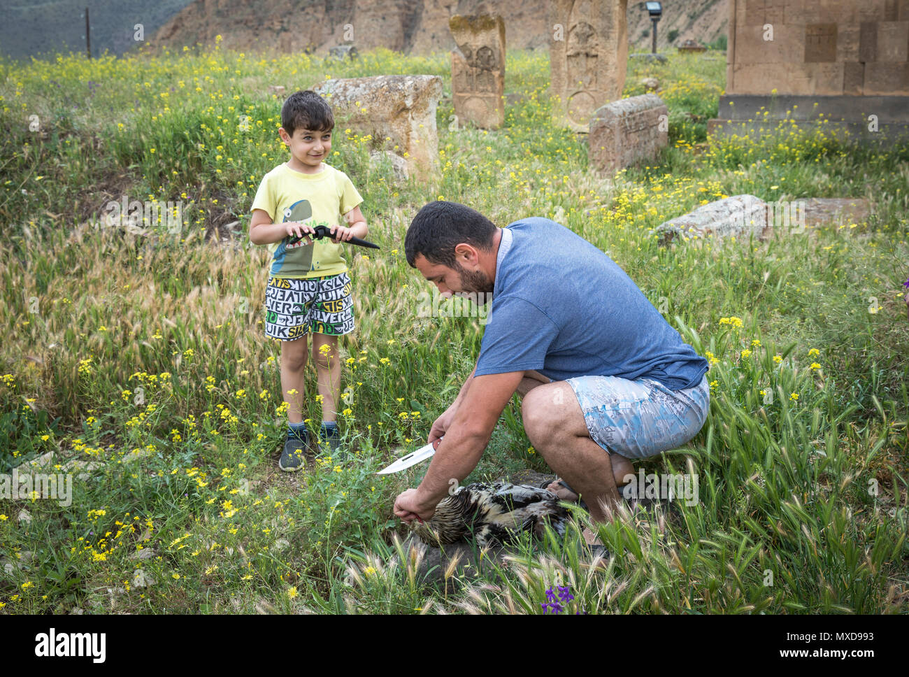 Areni, Armenia, 1st June, 2018: man is cutting a head of a rooster as a sacrifice to God Stock Photo