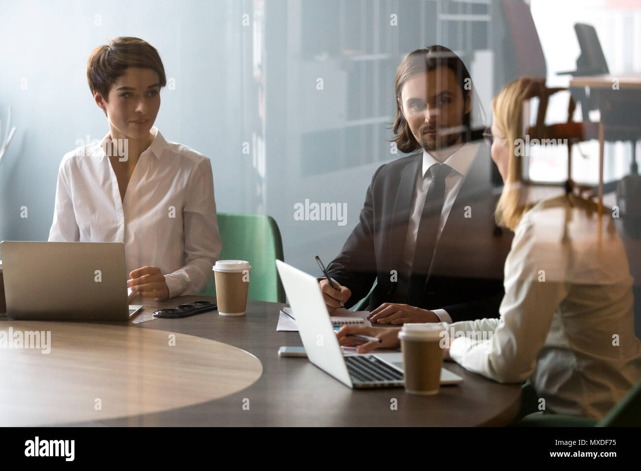 Businesswoman explaining project strategy to colleagues during m Stock Photo