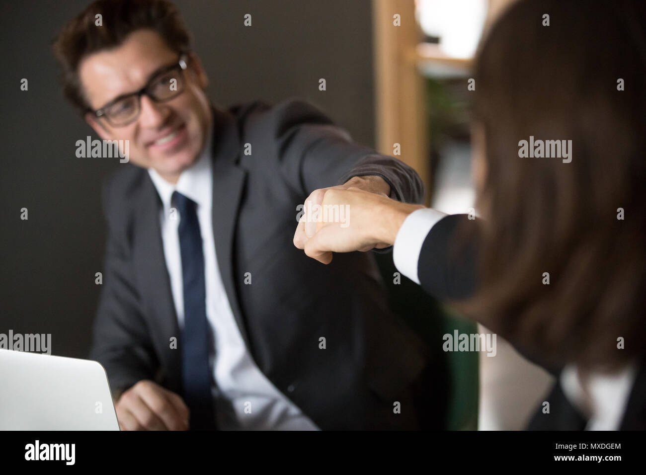 Colleagues giving fists bump celebrating shared business achieve Stock Photo