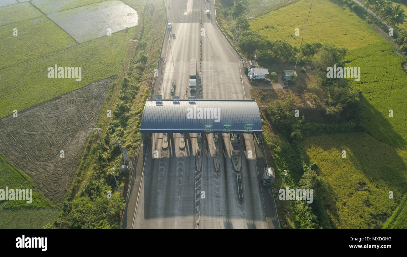 Highway with a toll payment point. Aerial view: Cars passing through the point of toll highway, toll station,Philippines, Luzon. Drone view on toll collection point on the motorway. Stock Photo