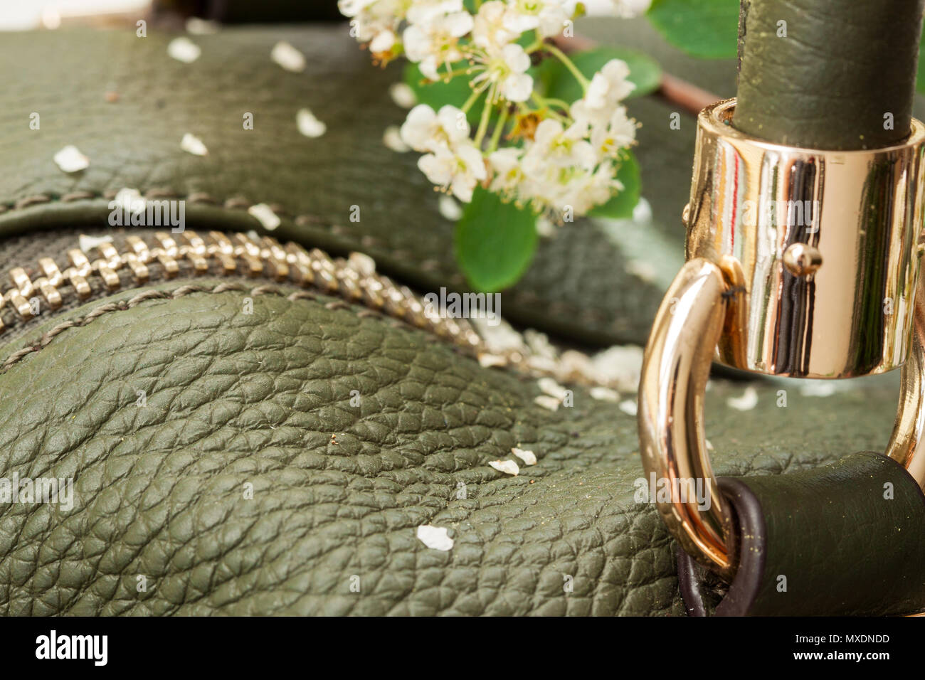 Detail of green leather bag and flowers Stock Photo