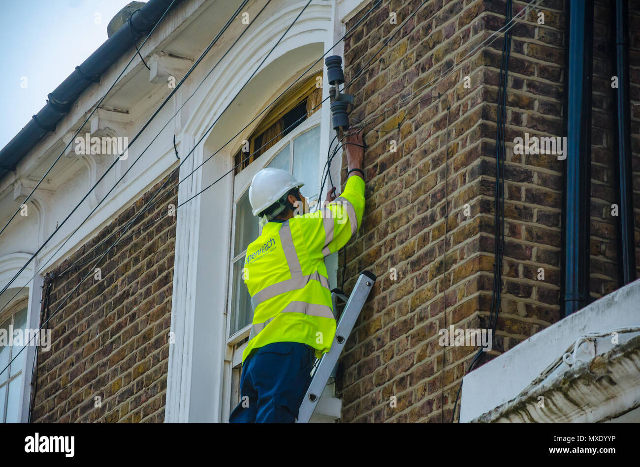 An Openreach engineer up a ladder working on a telephone line