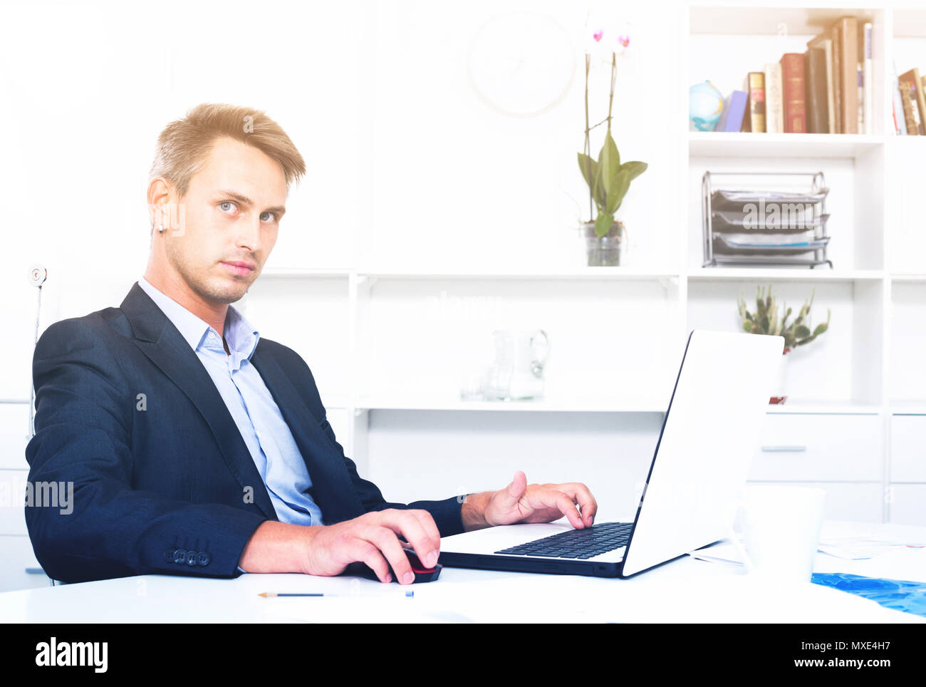 Serious Young Man Employee Sitting At Working Desk With Laptop In