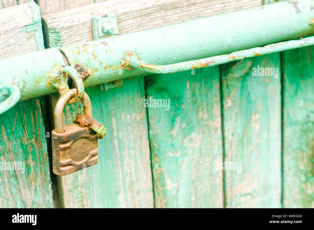 Old iron rusty padlock on the green wooden door Stock Photo - Alamy
