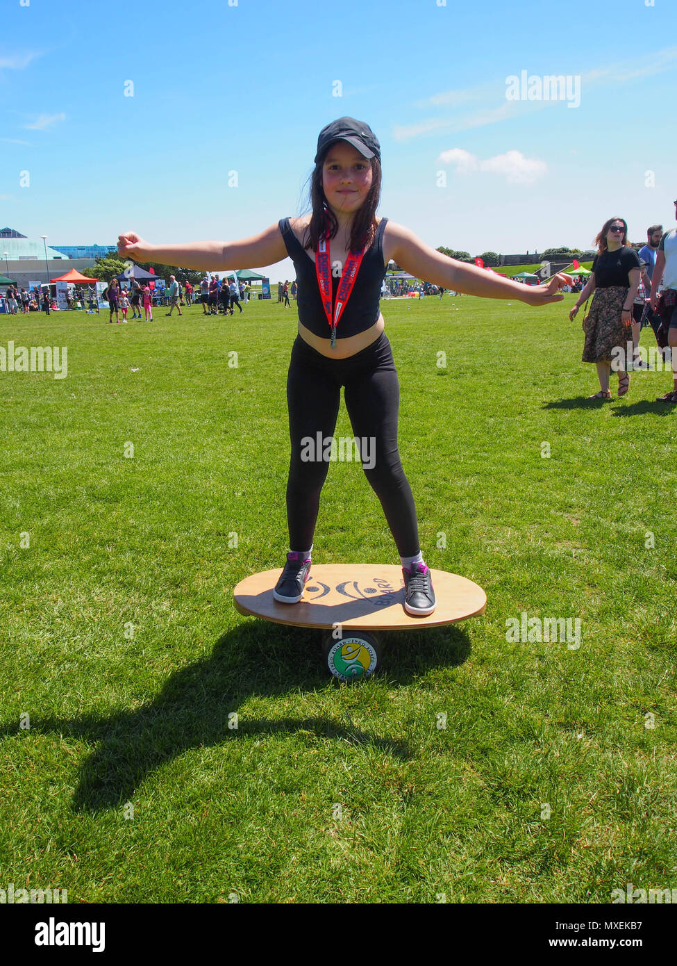 A young girl balances on a balance board Stock Photo