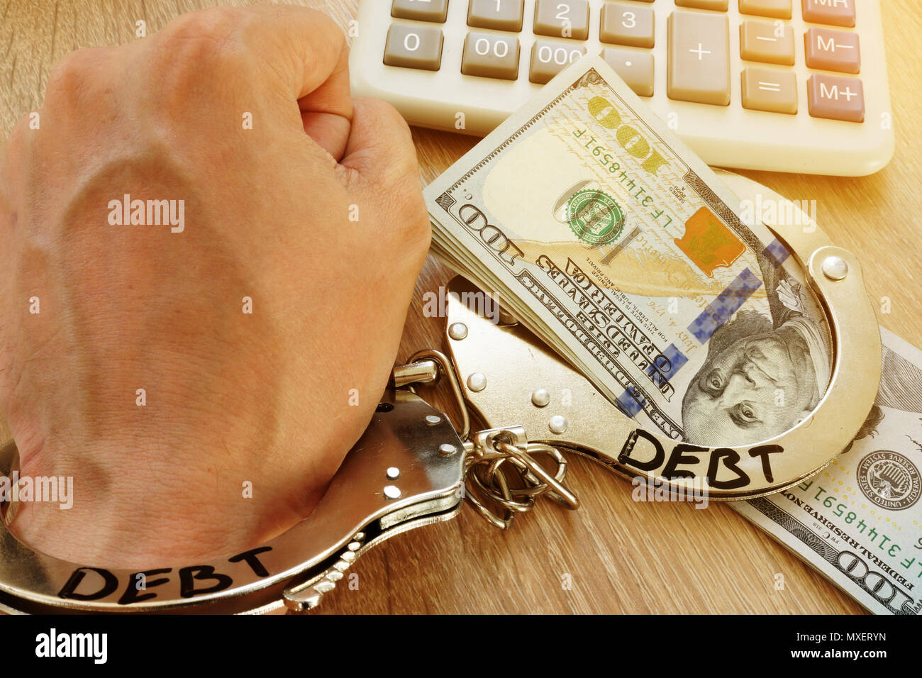 Problems with debt. Hand in handcuffs and money. Stock Photo