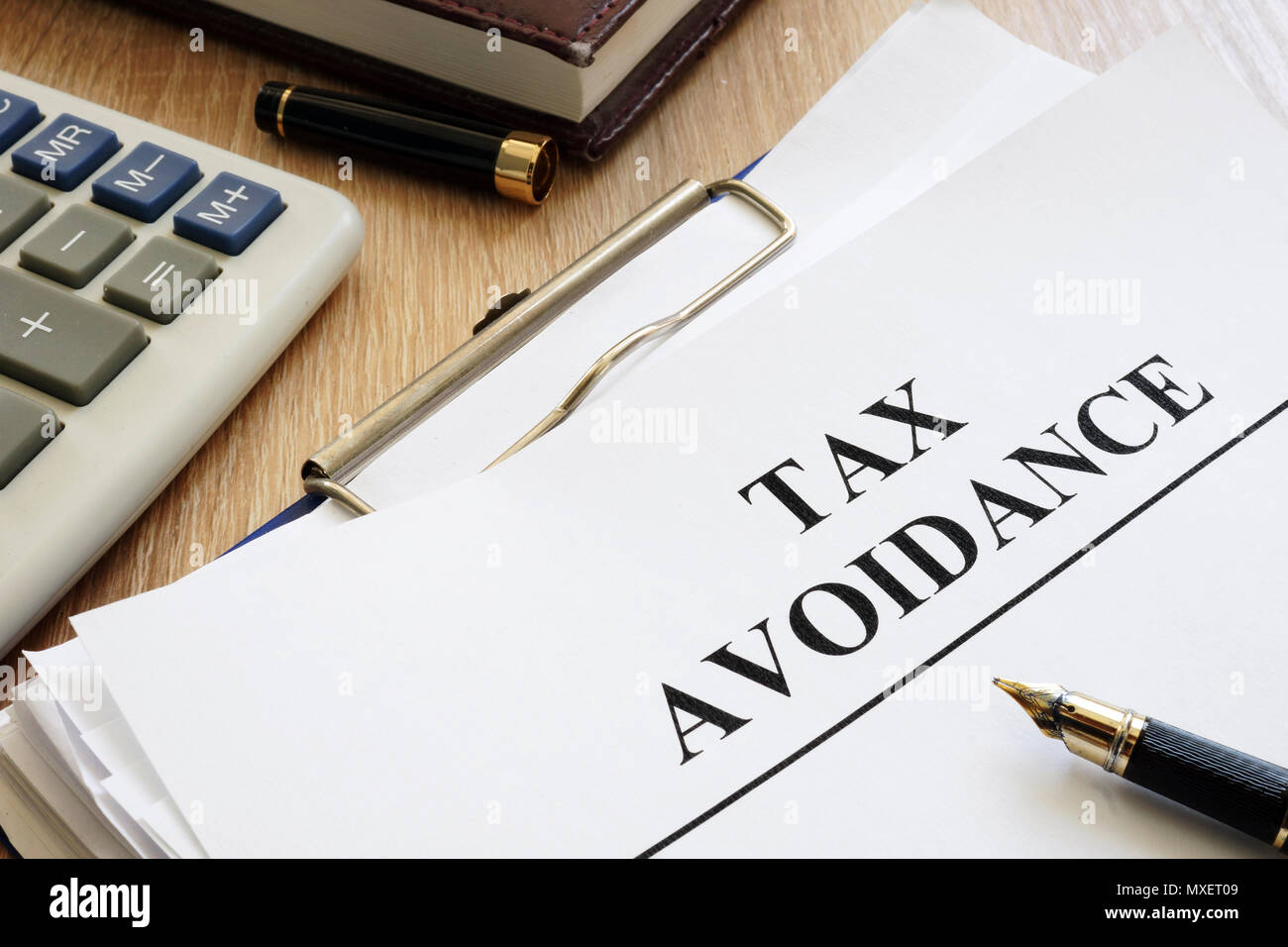 Documents about tax avoidance on a desk. Stock Photo