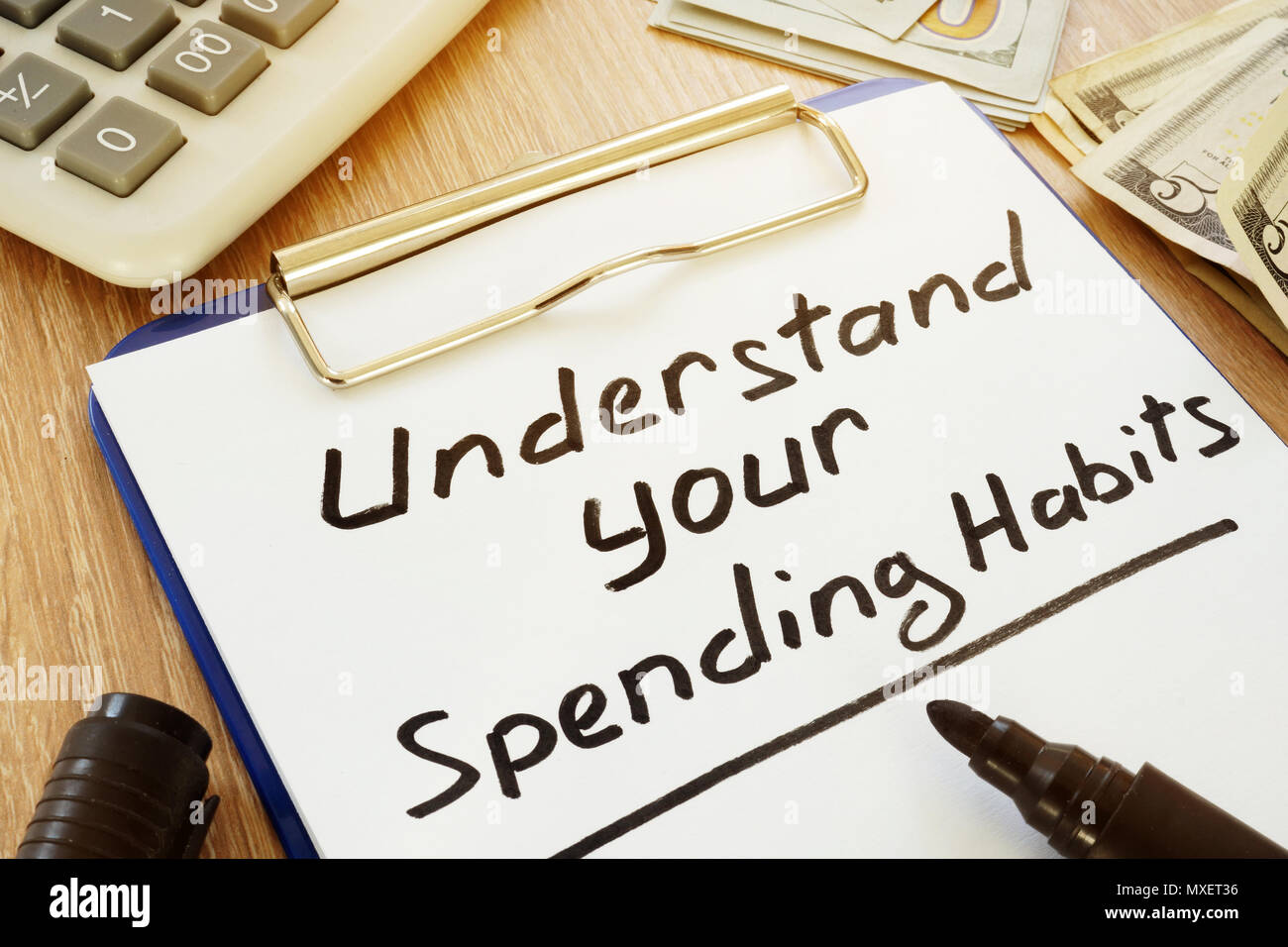 Understand your spending habits written on a clipboard. Stock Photo