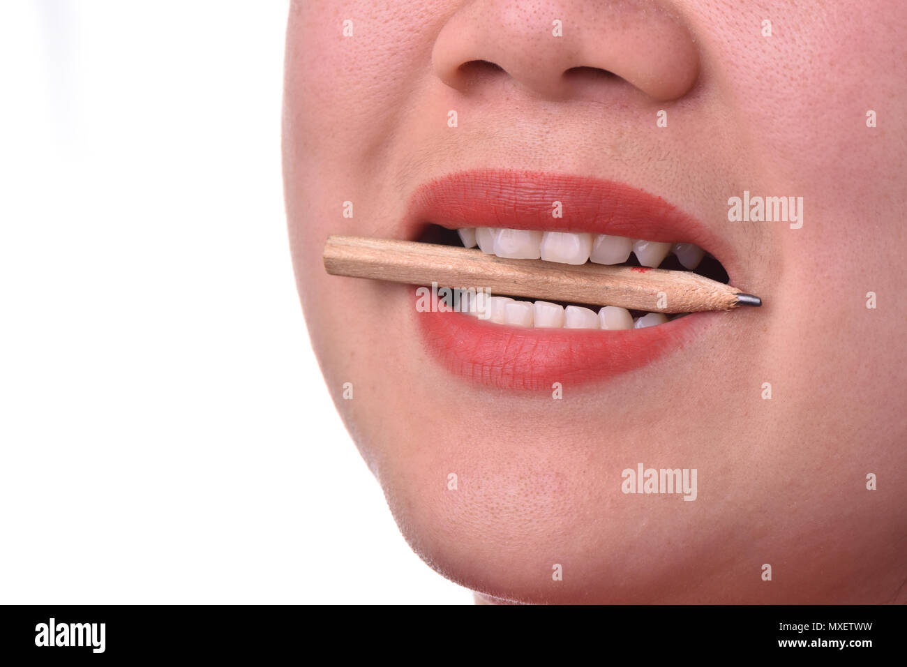 Close-up of woman with red lipstick bitting pencil Stock Photo