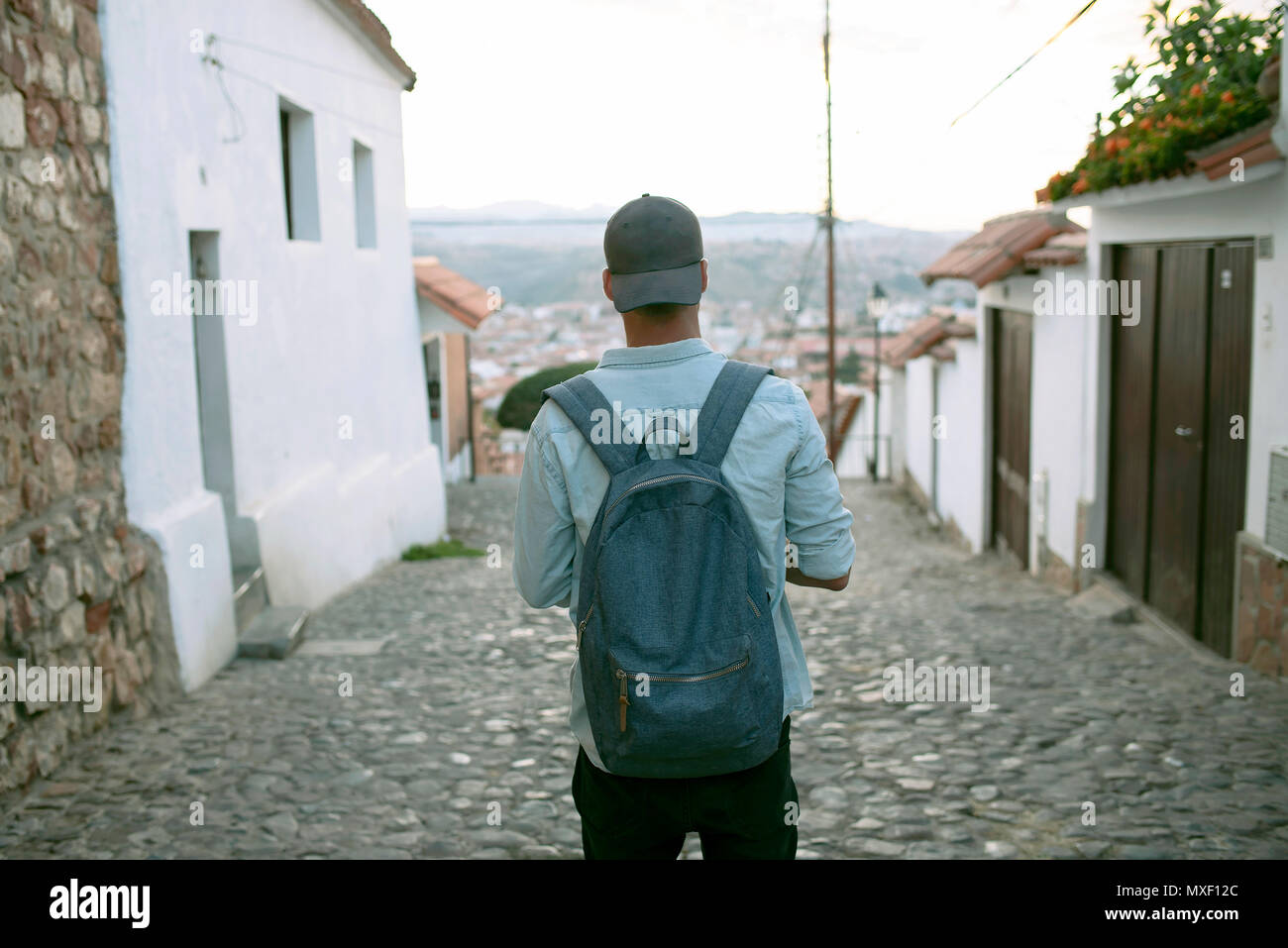 Rear view of tourist boy wearing backpack, exploring the town of Sucre, Bolivia. Stock Photo