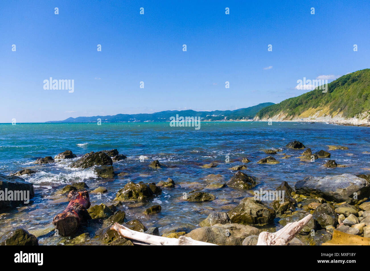 rocky sea shore with pebble beach, waves with foam Stock Photo