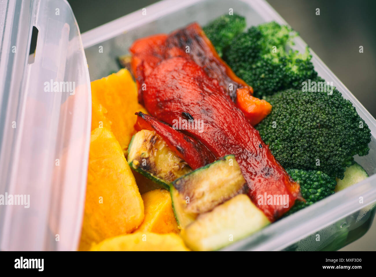 Packed Lunch, Roasted Vegetables Red Bell Pepper Broccoli Sweet Potato Zucchini in Tupperware Stock Photo