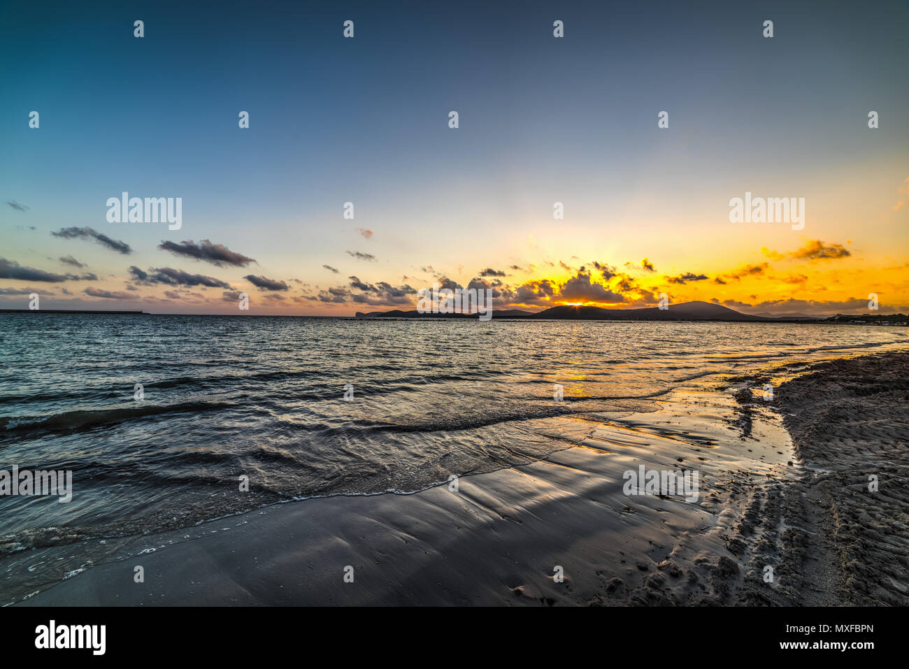 Fishing Pole On A Rocky Beach, Dock At Purple Sunset. Stock Photo