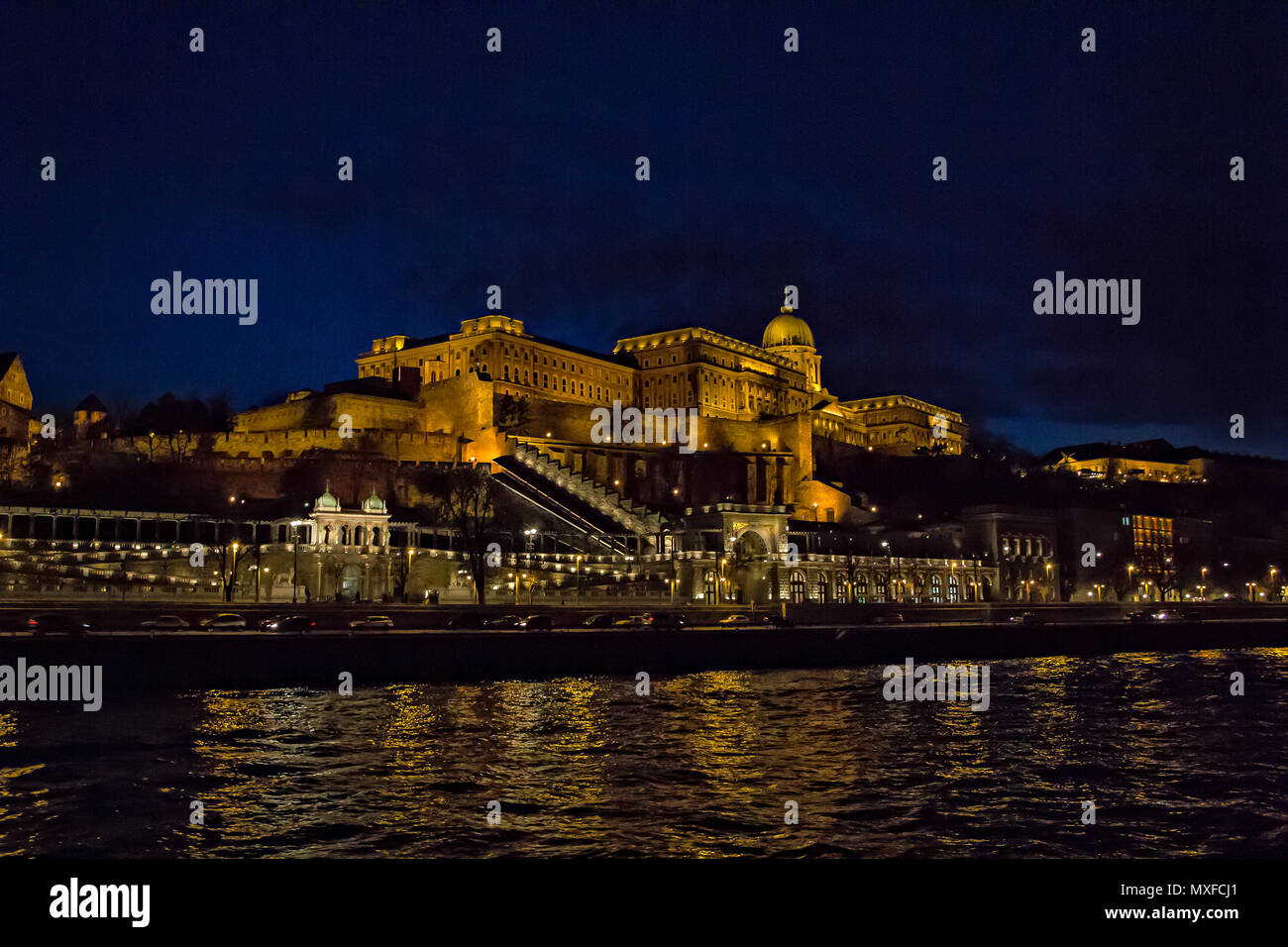 View over Buda side of Budapest with illuminated Buda castle and Danube river from viewpoint on a touristic motor ship at night in Budapest, Hungary Stock Photo