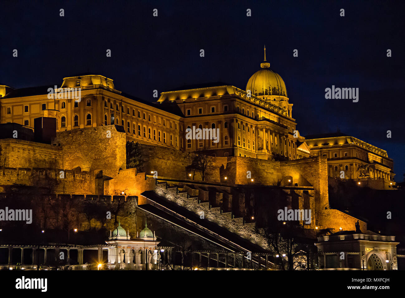 View over Buda side of Budapest with illuminated Buda castle and Danube river from viewpoint on a touristic motor ship at night in Budapest, Hungary Stock Photo