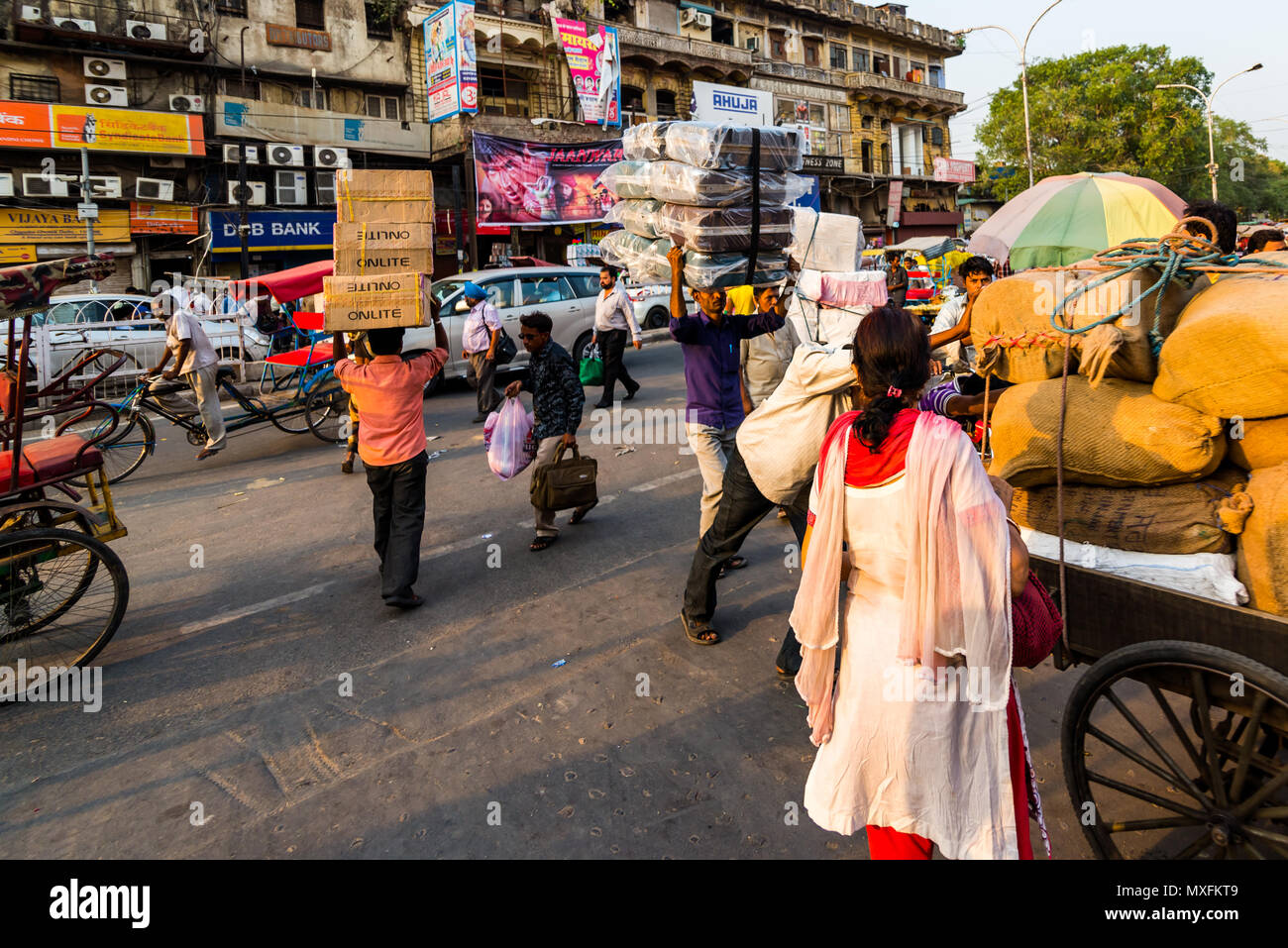 A very busy and crowded street in Old Delhi, India, with many passersby, porters pushing carts or carrying goods on their heads. Delhi  June 2015 Stock Photo