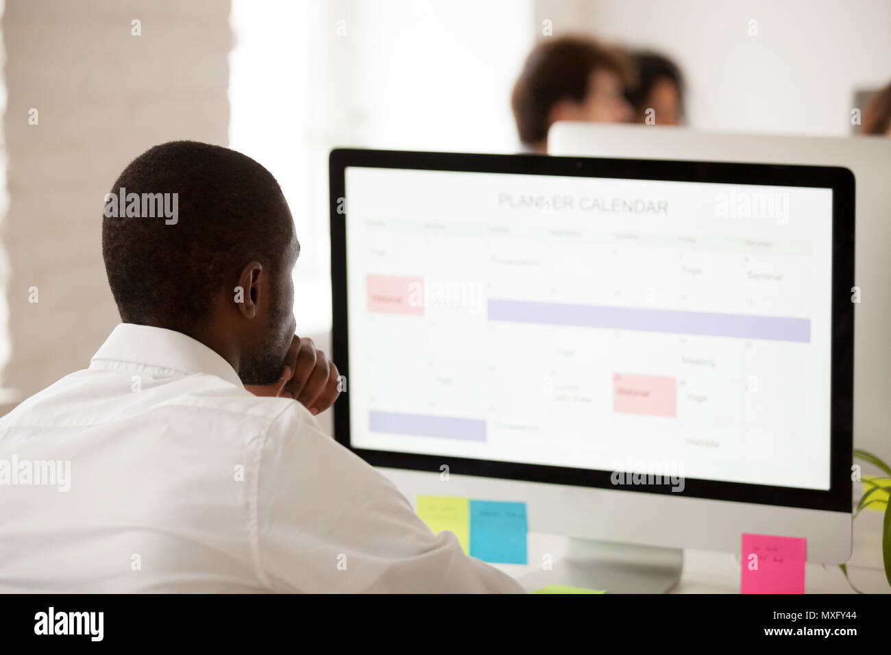 African American Worker Planning Work Schedule Using Desktop Pla Stock african-american-worker-planning-work-schedule-using-desktop-pla-stock