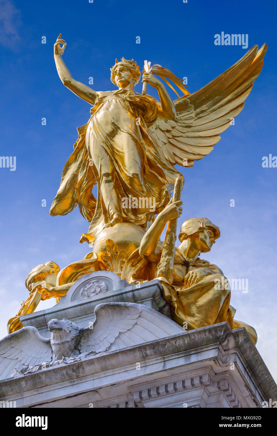 Looking up to the gilded bronze section of the Queen Victoria Memorial showing the Winged Victory Statue above with Constancy to the left and Courage  Stock Photo