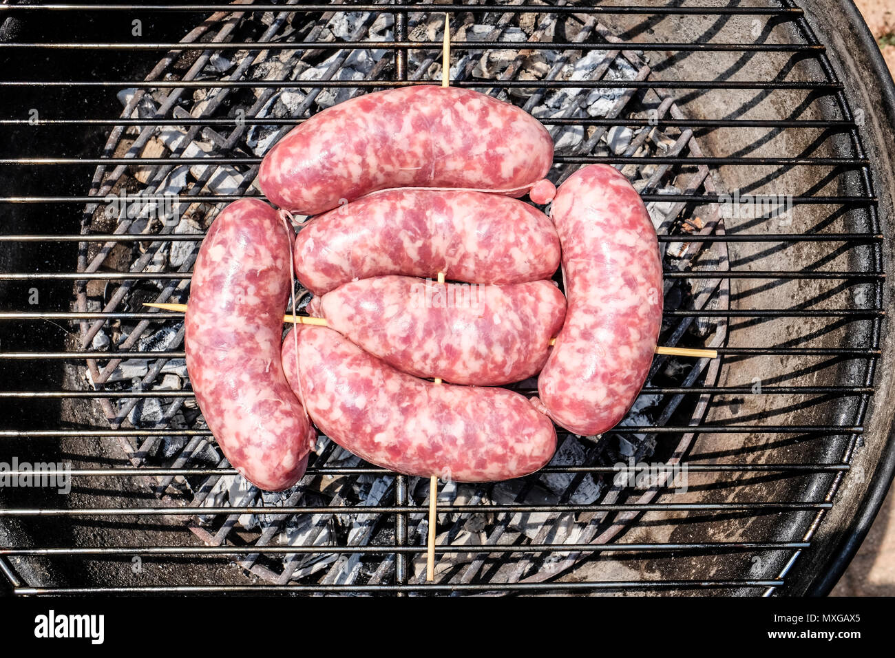 raw chorizo sausages on a grill outdoors Stock Photo Alamy