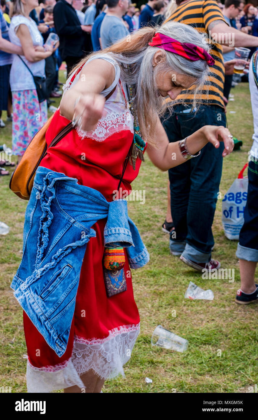 Woman with colourful clothes and long hair, dancing on her own, at the All Points East music festival, 3rd June 2018, Victoria Park, London, England, UK Stock Photo