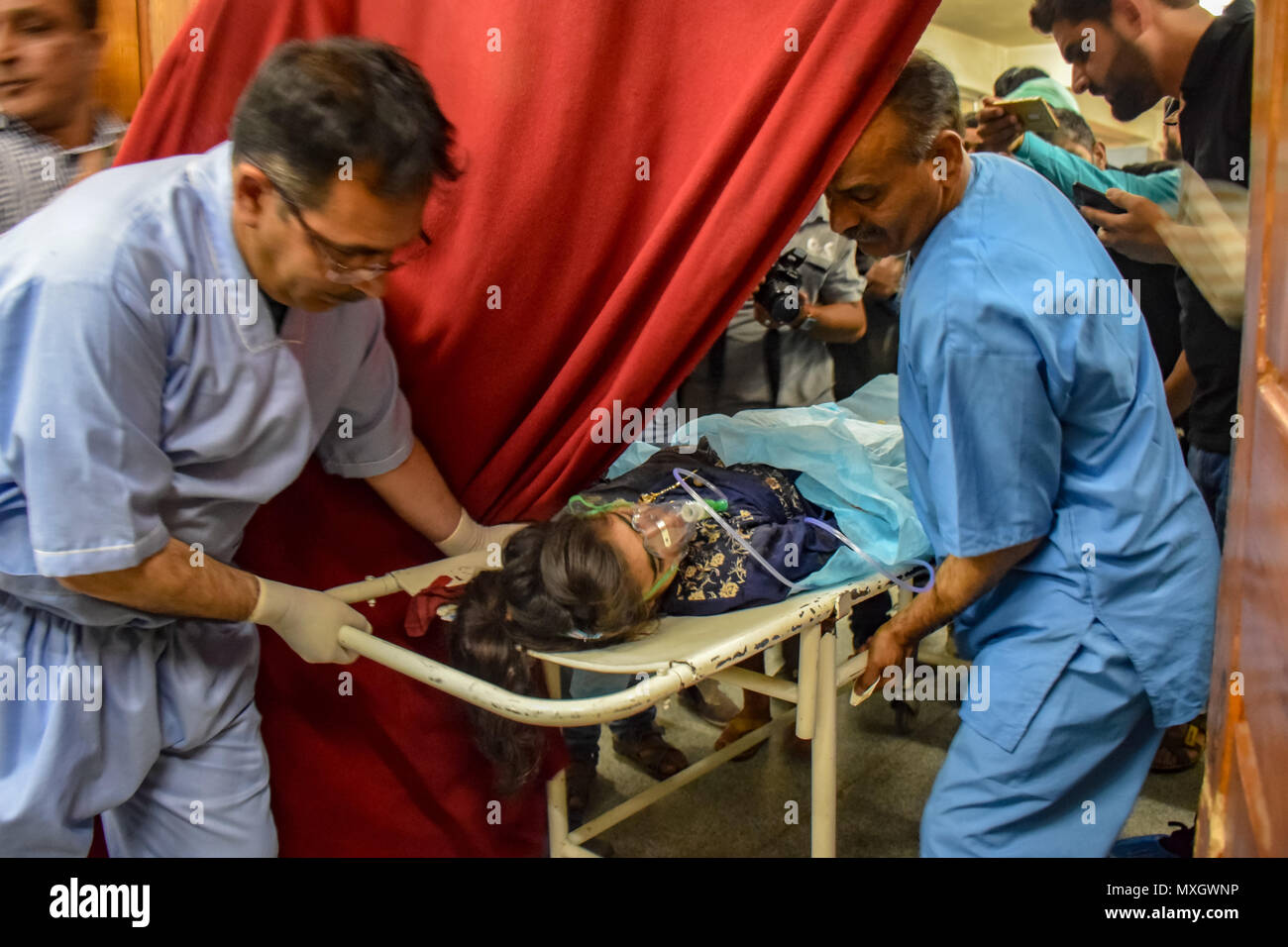 June 4, 2018 - Srinagar, Jammu & Kashmir, India - (EDITORS NOTE: Image contains graphic content) Kashmiris carry 13-year-old Nadia, who was injured in an explosion, on a stretcher for treatment at a local hospital in Srinagar, Indian Kashmir on Monday. A grenade exploded on a busy road in the southern town of Shopian in Indian-controlled Kashmir wounding at least 12 civilians and four policemen on Monday, police said. Credit: Abbas Idrees/SOPA Images/ZUMA Wire/Alamy Live News Stock Photo