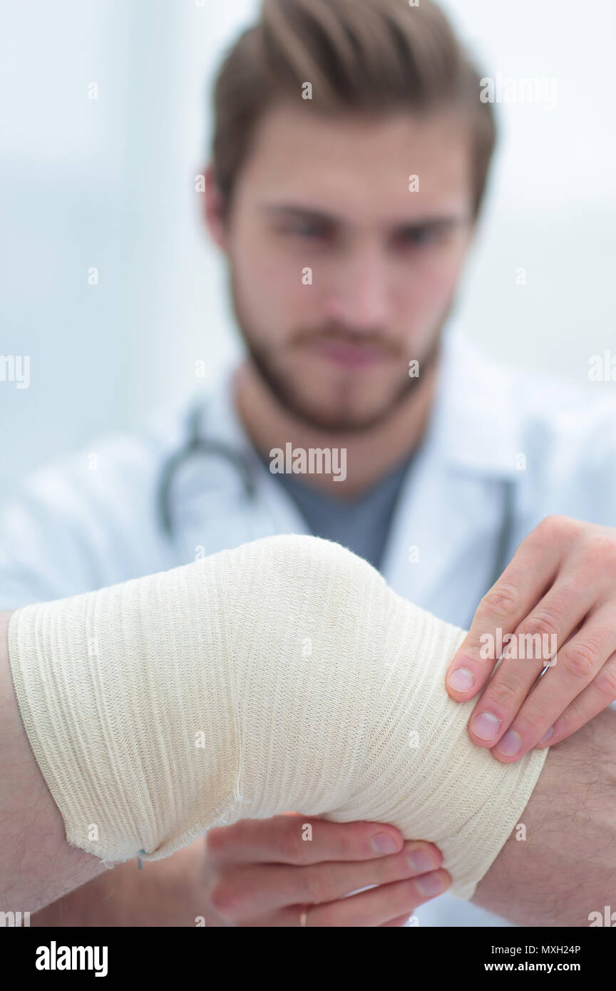 traumatologist examining the bandage on his knee Stock Photo Alamy