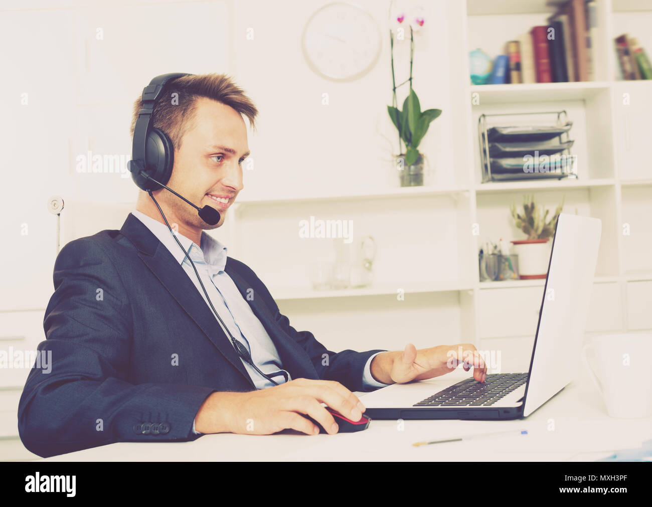 Laughing man talking on headset at company office Stock Photo