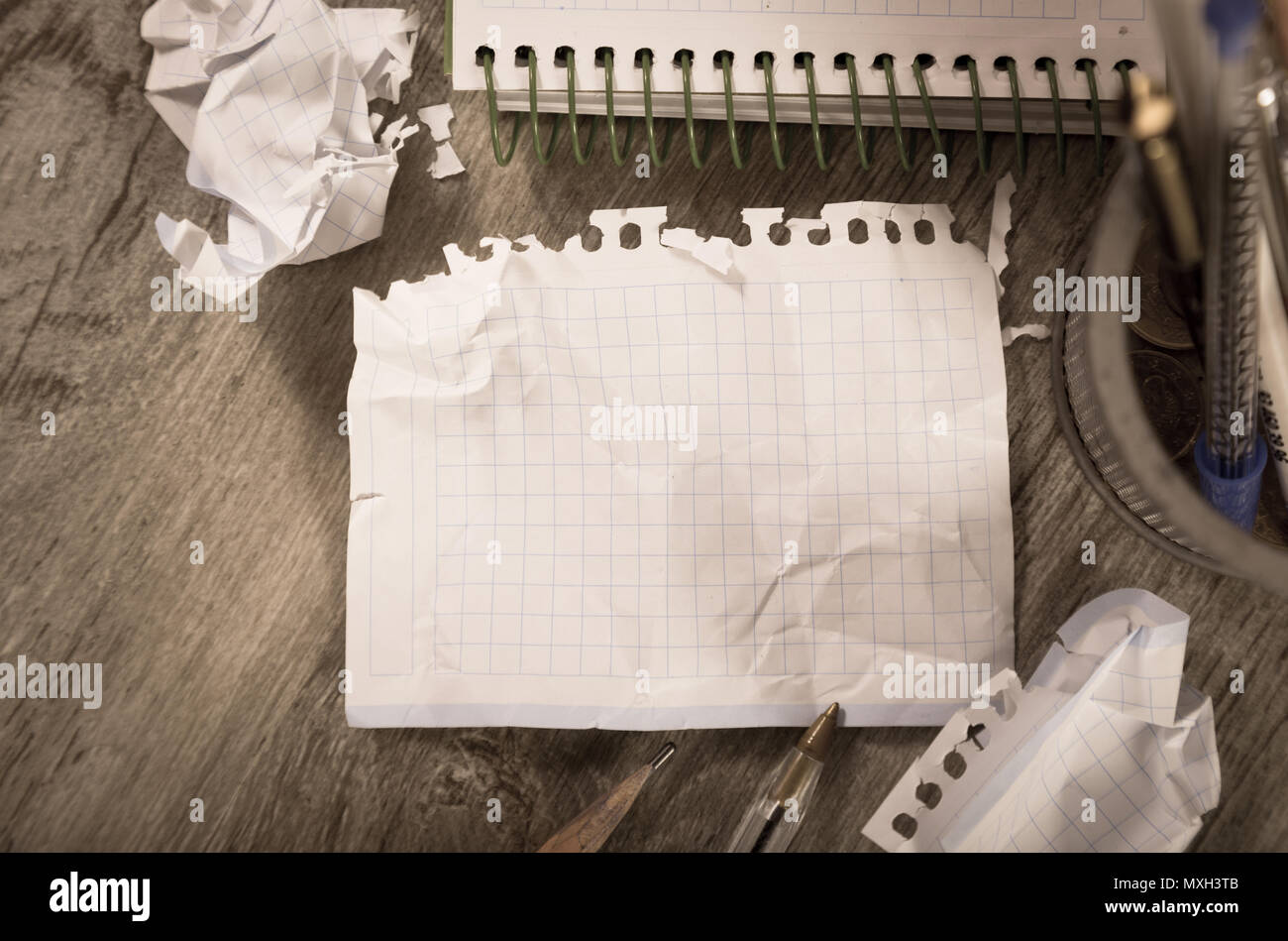 Empty crumpled pages and notebook lying on wooden surface Stock Photo