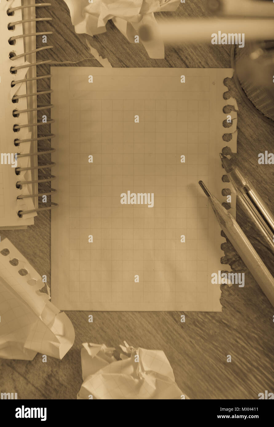 Empty crumpled pages and notebook lying on wooden surface Stock Photo