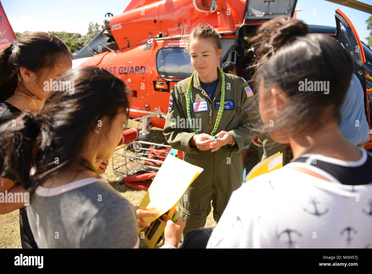 Lt. Lisa Davis, an MH-65 Dolphin helicopter pilot at Coast Guard Air Station Barbers Point, Oahu, speaks with several teens during a career day at Lanai High and Elementary School in Lanai, Nov. 2, 2016. Several crewmembers from Air Station Barbers Point flew from Oahu to speak with the children about possible career opportunities in the Coast Guard and aviation as well as providing an up close look at an MH-65 Dolphin helicopter. (U.S. Coast Guard photo by Petty Officer 2nd Class Tara Molle) Stock Photo