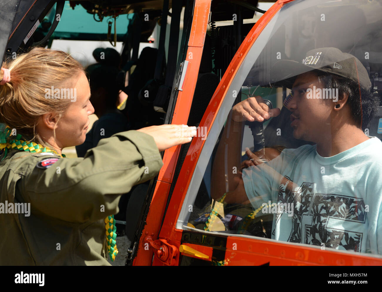Lt. Lisa Davis, an MH-65 Dolphin helicopter pilot at Coast Guard Air Station Barbers Point, Oahu, speaks with a teenager about flying during a career day at Lanai High and Elementary School in Lanai, Nov. 2, 2016. Several crewmembers from Air Station Barbers Point flew from Oahu to speak with the children about possible career opportunities in the Coast Guard and aviation as well as providing an up close look at an MH-65 Dolphin helicopter. (U.S. Coast Guard photo by Petty Officer 2nd Class Tara Molle) Stock Photo