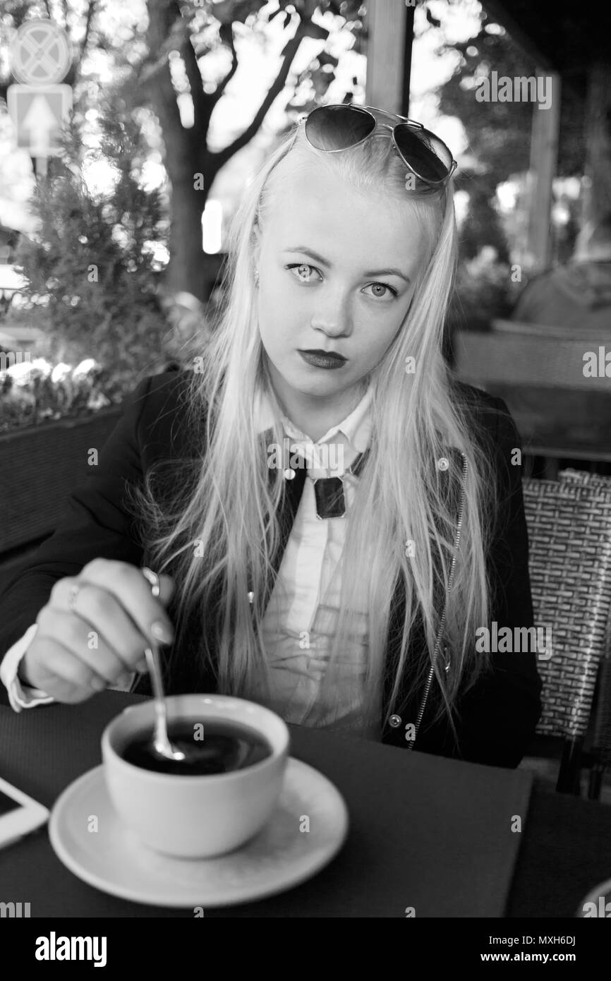 serious sad woman with tea mug in street cafe looking at camera Stock Photo