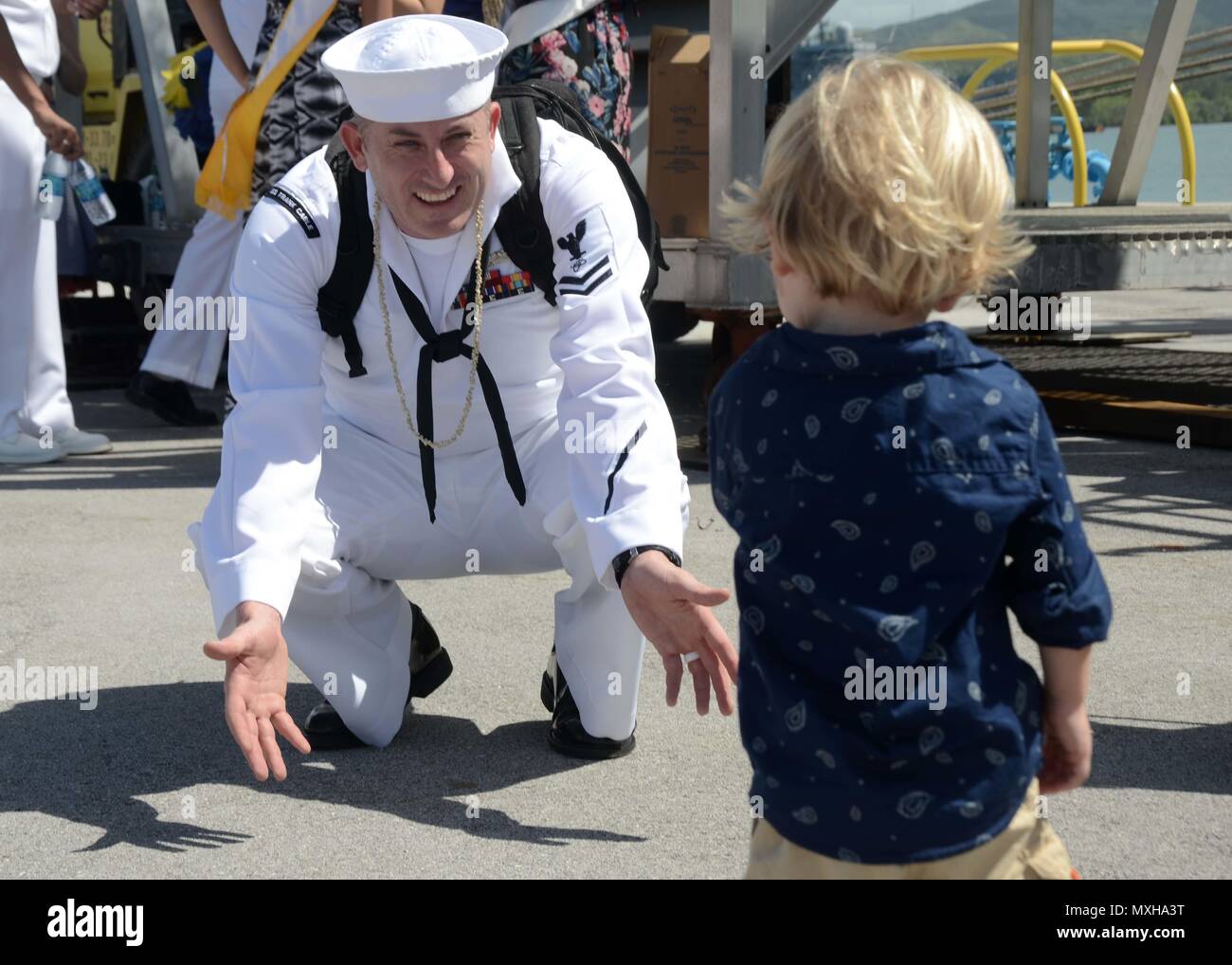161108-N-WA347-139 SANTA RITA, Guam (Nov. 8, 2016) – Petty Officer 2nd Class Jay Cogger, native of Atlantic Beach, N.C., assigned to the submarine tender USS Frank Cable (AS 40), greets his son on the pier at Naval Base Guam after completing a five-month deployment, Nov. 8.  Frank Cable departed Guam June 6, was a persistent presence throughout the Indo-Asia-Pacific region during its deployment providing vital flexibility to the fleet commanders, extending the range and impact of U.S. naval forces in the U.S. Navy’s 5th and 7th Fleets.  Forward deployed to Guam, Frank Cable’s combined Navy and Stock Photo