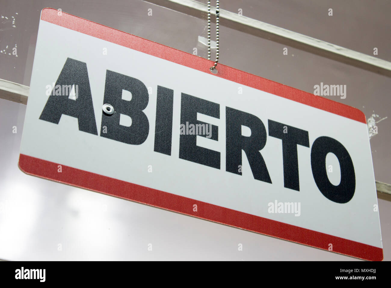 An spanish open sign hanging in a store. Abierto meaning open Stock