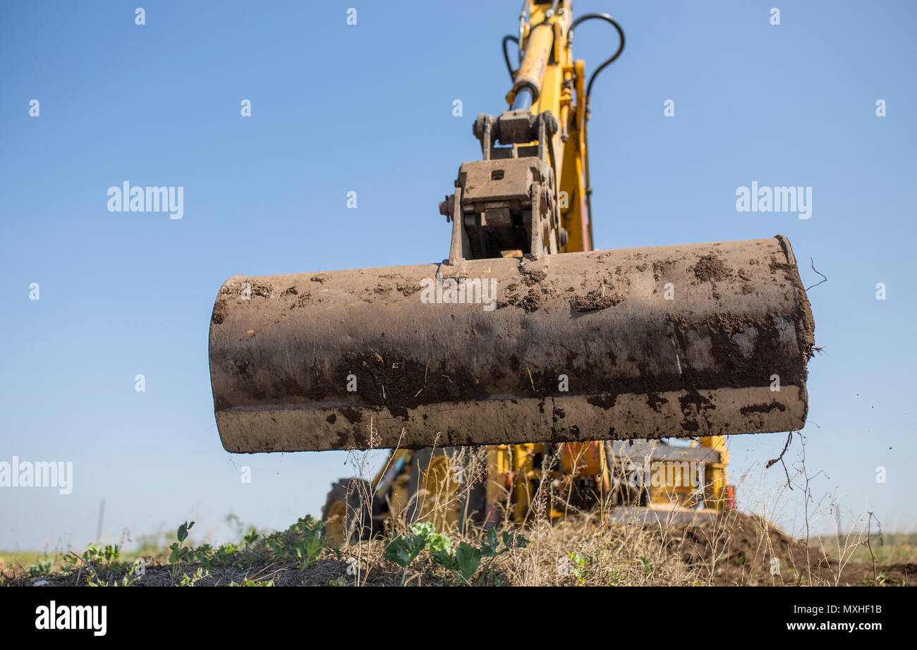 Backhoe tractor working with back long shovel. The machine is prepare the ground Stock Photo