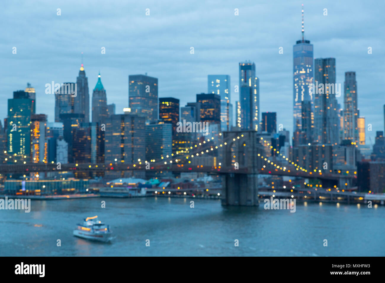 Out of focus image of Brooklyn Bridge and Lower Manhattan skyline at night, New York city, USA. Stock Photo