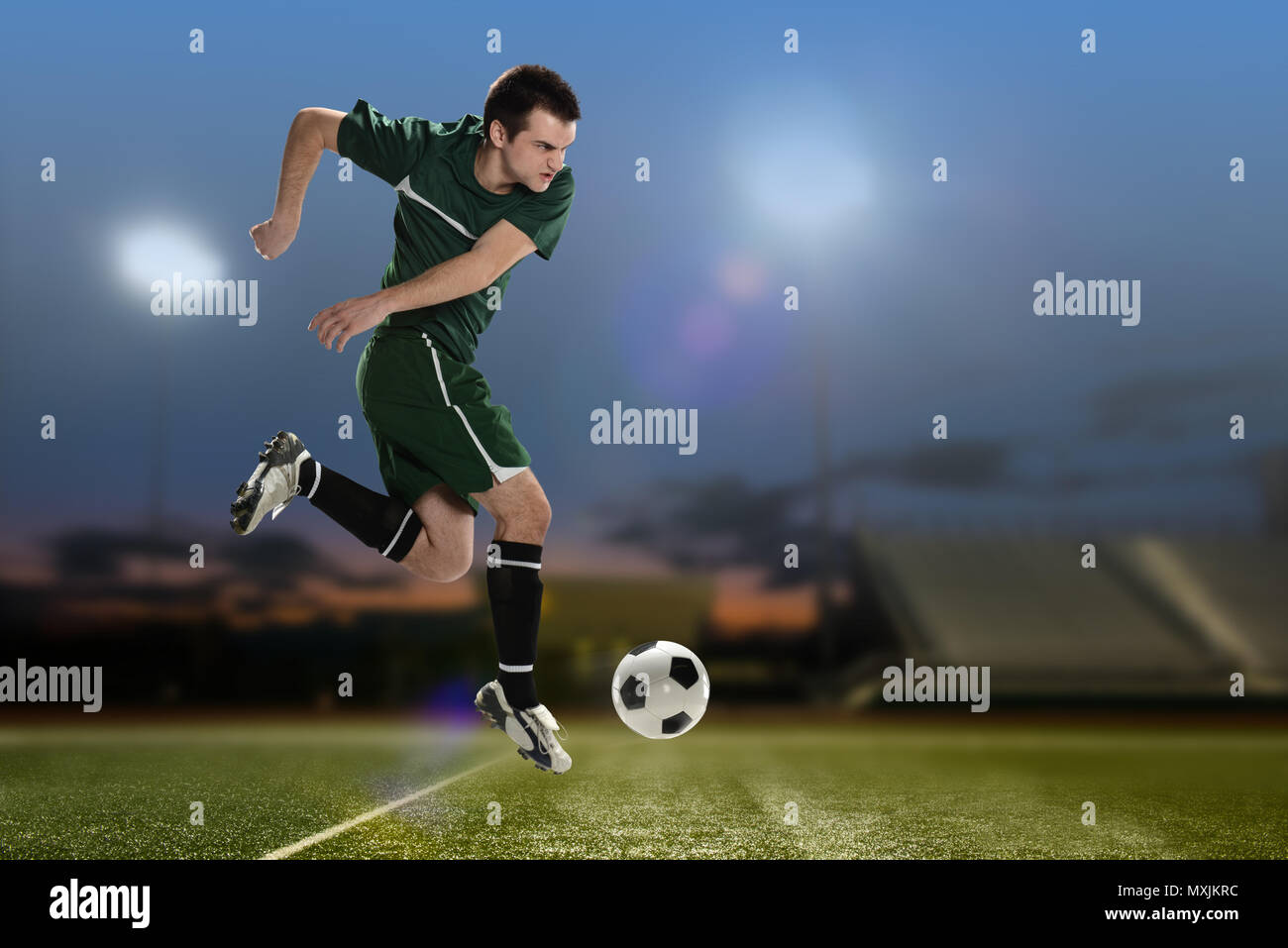 Soccer Player kicking the ball inside a football stadium at night Stock Photo Alamy